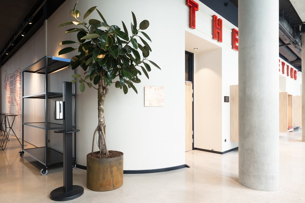 Cortensteel cylinder-kruka i miljö, placerad på golv i modernt inredningskontor med växt