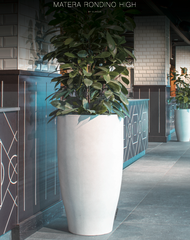 Vit rundformad höga kruka med växt i modern inredning/entré miljö