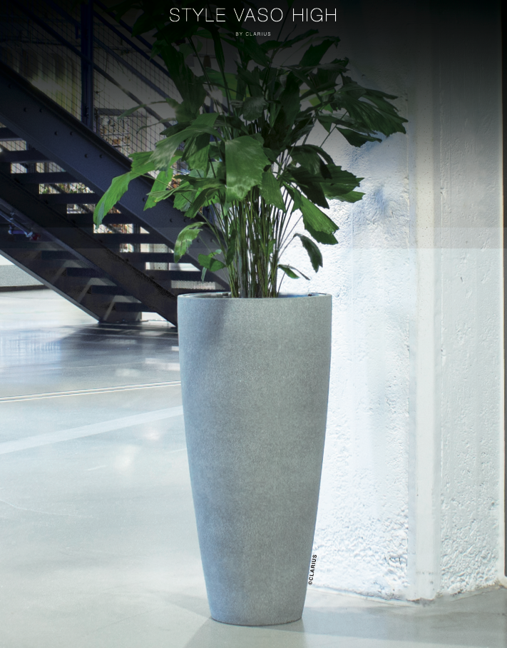 Grå vaso high-kruka med grön växt i modern inredning vid trappa